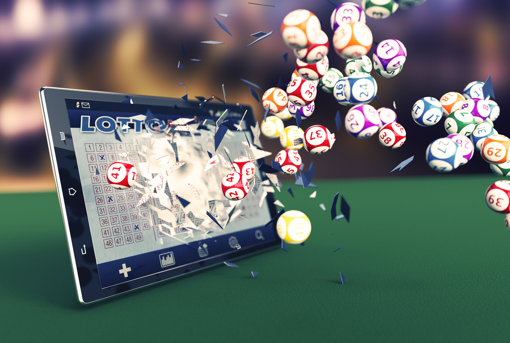 Lottokugeln, die aus dem Display eines Tablets herausfliegen.